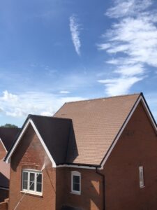 A new pitched roof with tiles installed on a residential property.