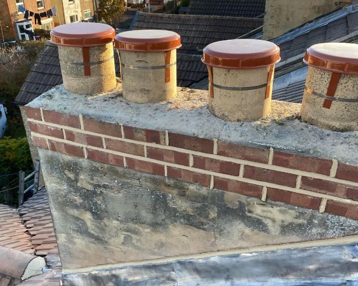 A chimney stack that has been repaired using new chimney caps and mortar.