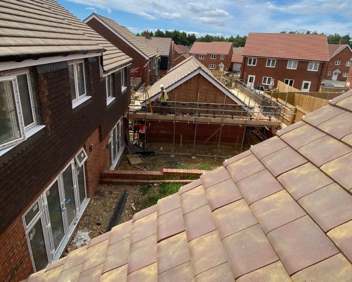 Roofing team installing a new roof on a garage on a new build site in Gosport.